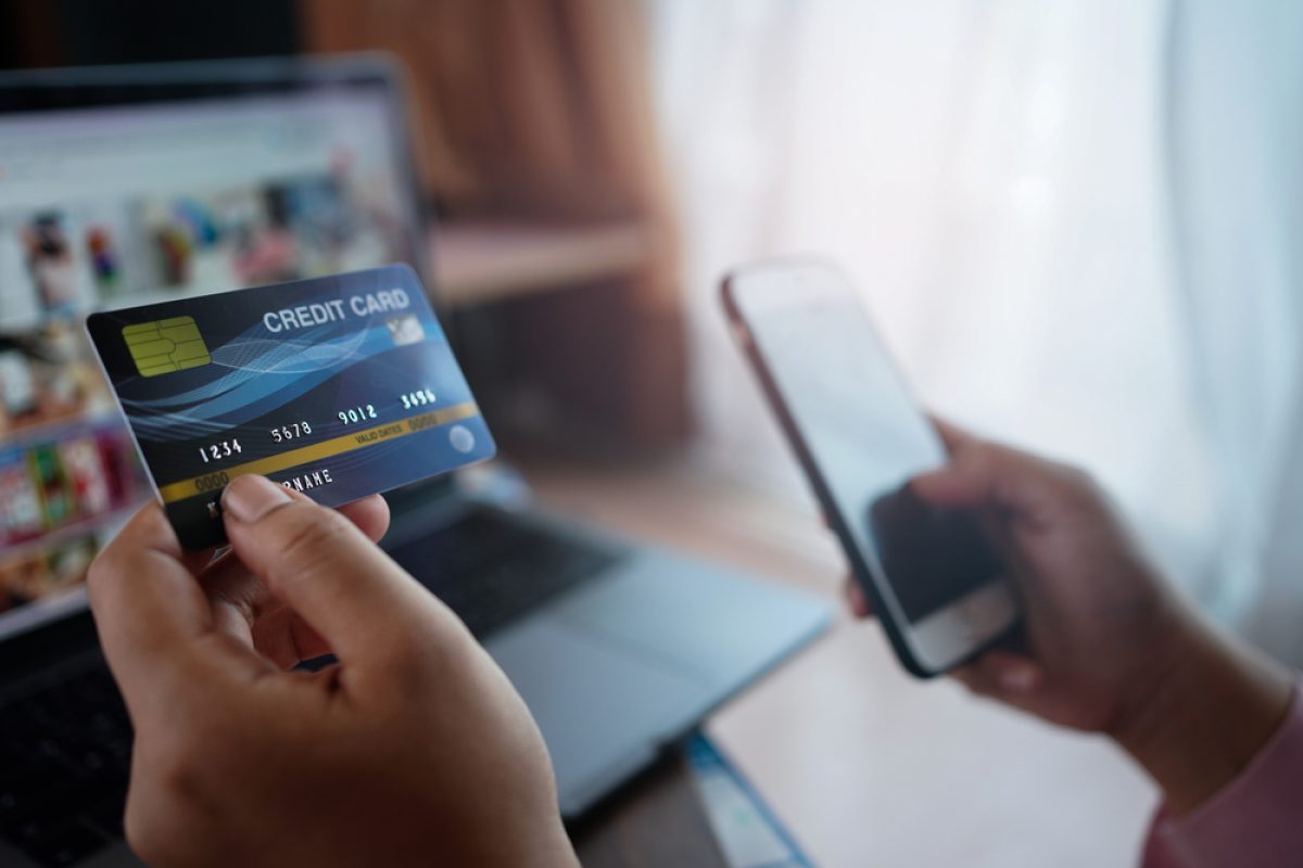 Woman's,Hands,Holding,A,Credit,Card,And,Using,Laptop,And